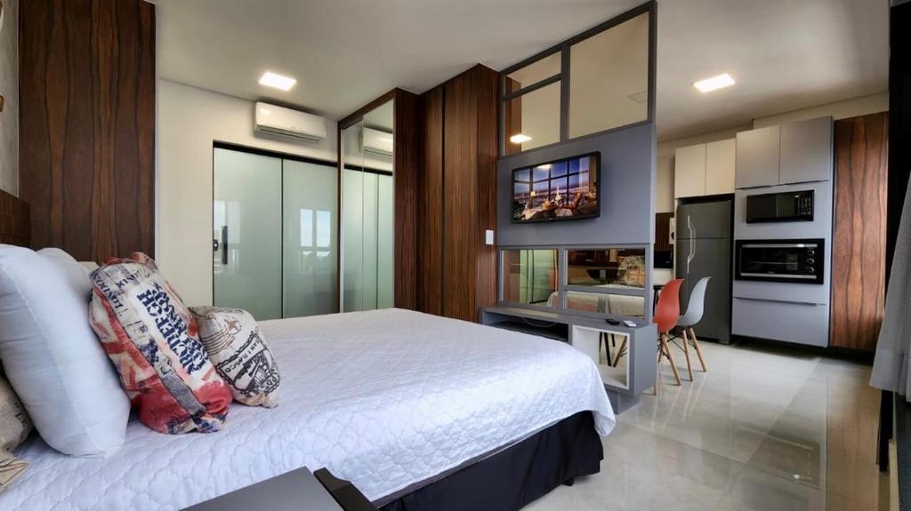 大坎普Estúdio Ultra Luxo com Vista Panorâmica的一间带大床的卧室和一间厨房