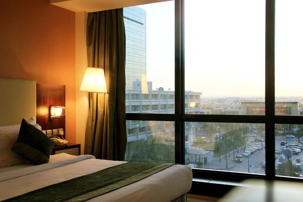 利雅德Business Inn Olaya的酒店客房设有一张床和一个大窗户