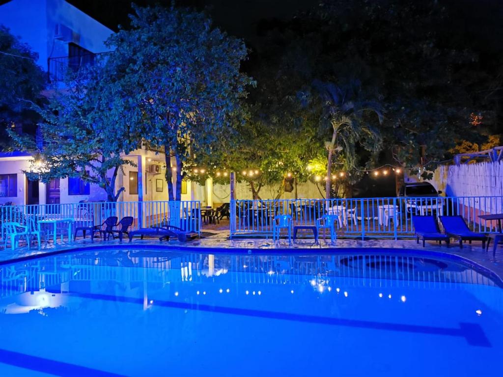 圣菲德安蒂奥基亚Hosteria El Castellano的夜间游泳池,配有桌椅