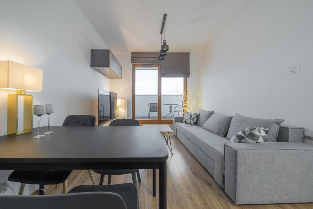 格但斯克Apartament Kapitalny的客厅配有灰色的沙发和桌子