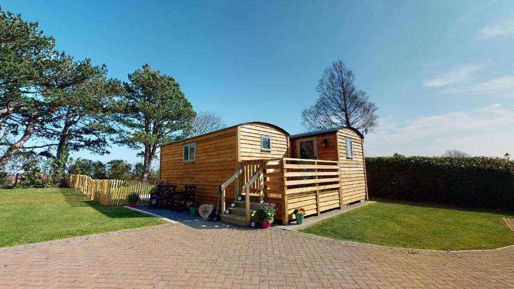 兰迪德诺Luxury Twin Shepherds Hut - Cosy & Romantic的坐在院子顶上的一个小房子