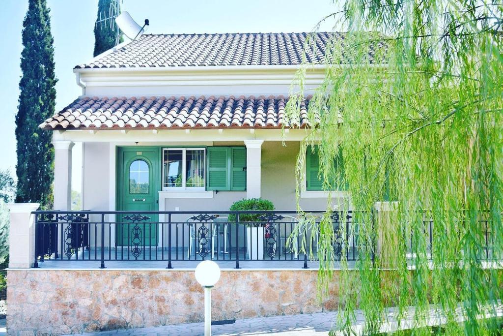 古维亚Spyridoula Resort Hotel in Corfu的一座带绿门和阳台的房子