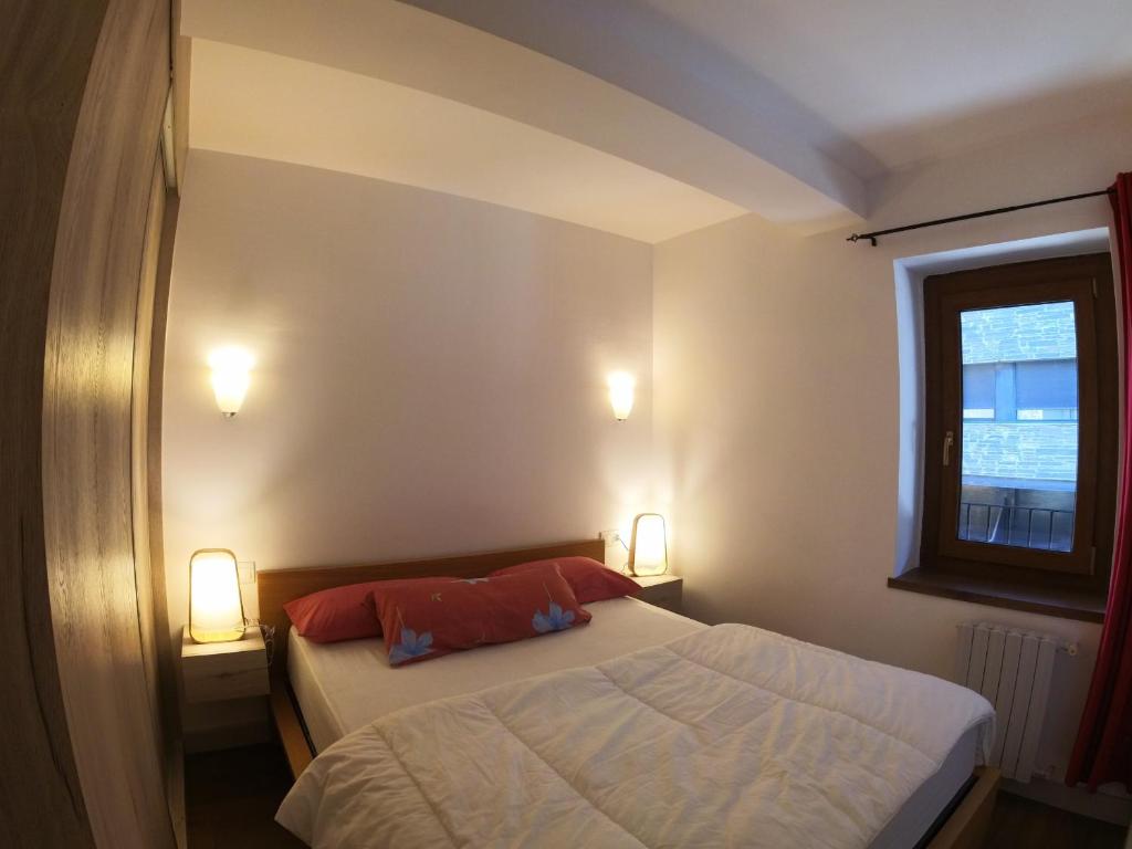 索尔德乌Soldeu Paradis Solneu的一间带一张床和两盏灯的小卧室
