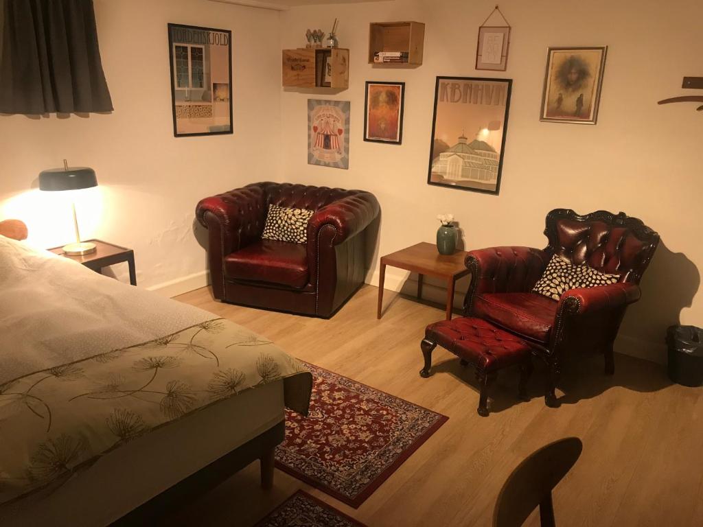 哥本哈根Comfortable Large Room King S bed near CPH centre的一间卧室配有两把椅子、一张床和一张桌子