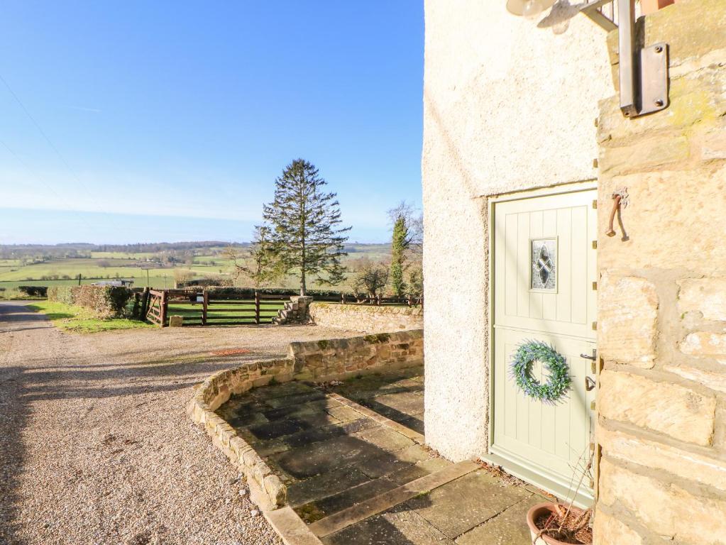 GillingThe Stable, Sedbury Park Farm的建筑物一侧有花圈的门