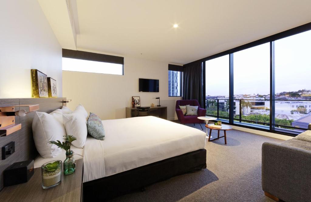 布里斯班布里斯班阿尔法马赛克佛特谷酒店的一间带大床的卧室和一间客厅