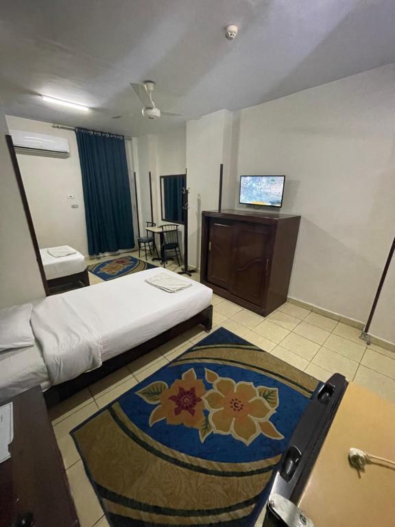 QināGrand Hotel Qena的酒店客房,配有床和电视