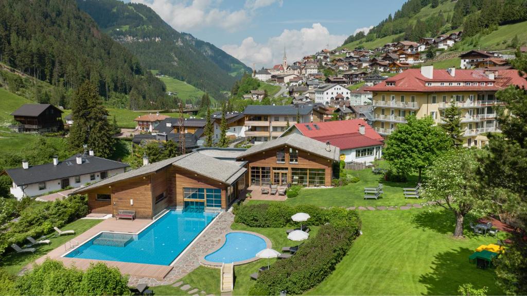 圣克里斯蒂娜Family Hotel Posta的享有带游泳池的度假村的空中景致