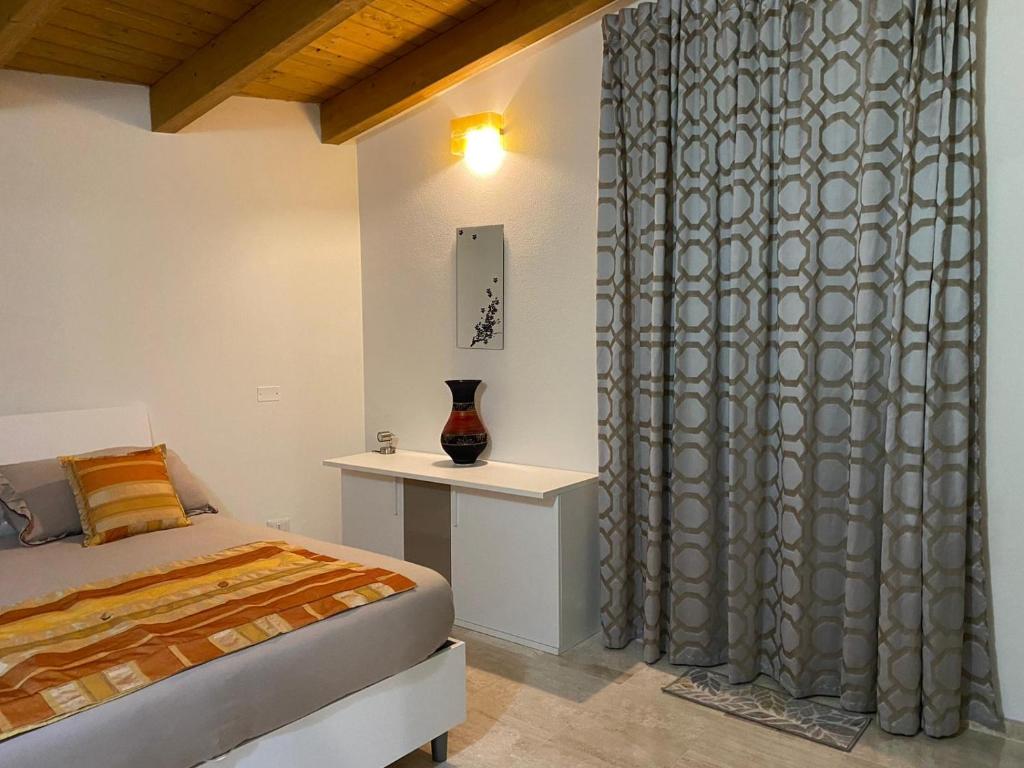 努奥罗Casa Ghirthalos的一间卧室配有床和带窗帘的窗户