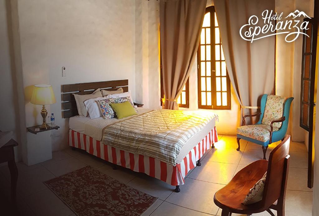埃斯特利Hotel Esperanza Estelí的一间卧室配有一张床、两把椅子和一个窗户