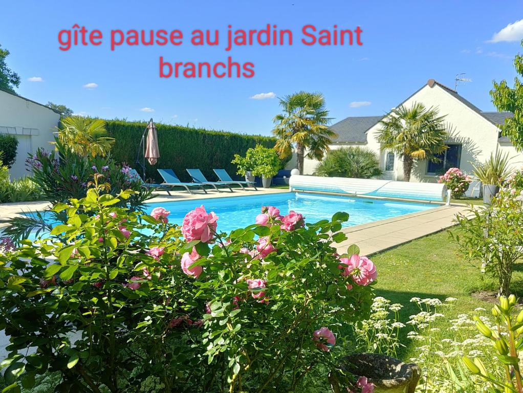 Saint-BranchsGîte pause au jardin的一座带粉红色花卉游泳池的房子