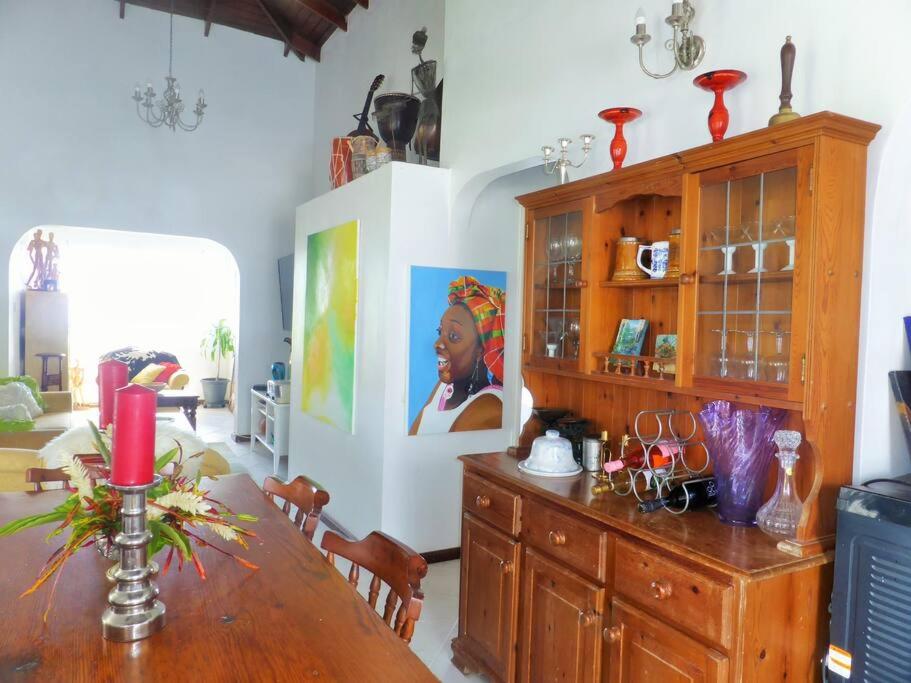 MicoudSelen's Apartment in Ti Rocher Micoud Saint Lucia的一间带桌子和大橱柜的用餐室