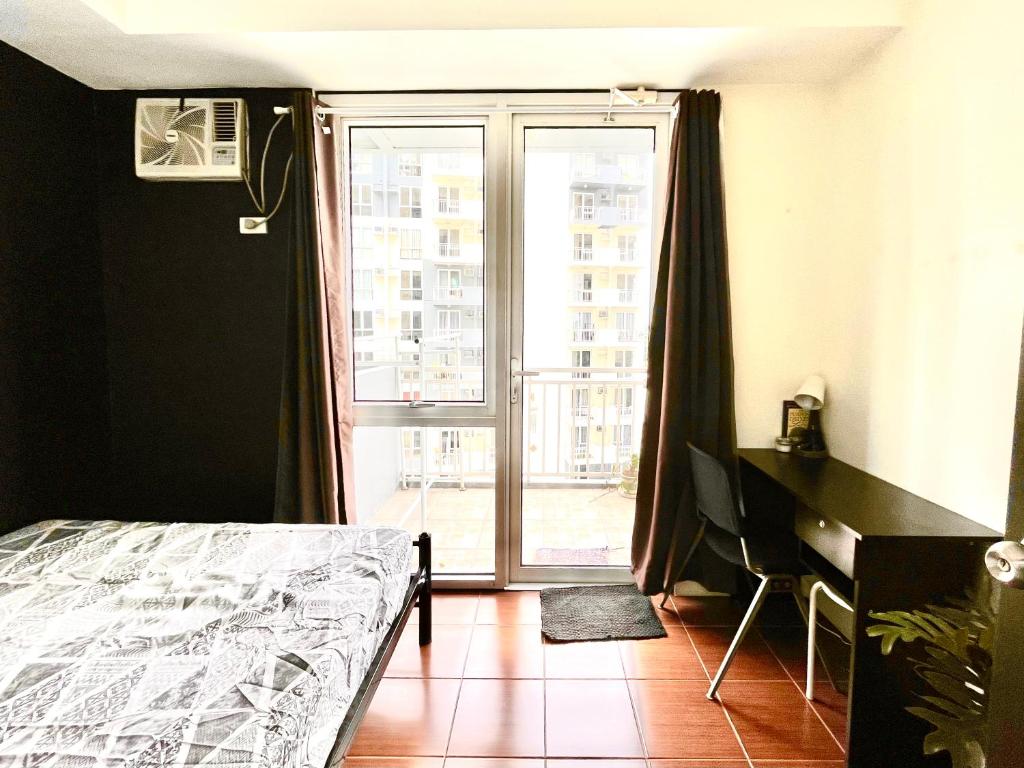 马尼拉Mey’s Condo in Pasig - 1BR with Balcony的一间卧室设有一张床和一个大窗户