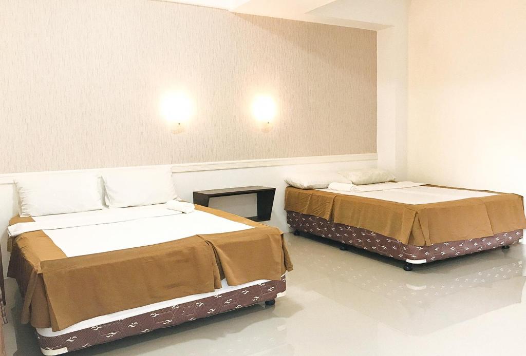 班塔延岛L and V Bantayan Guest House的一间客房内配有两张床的房间