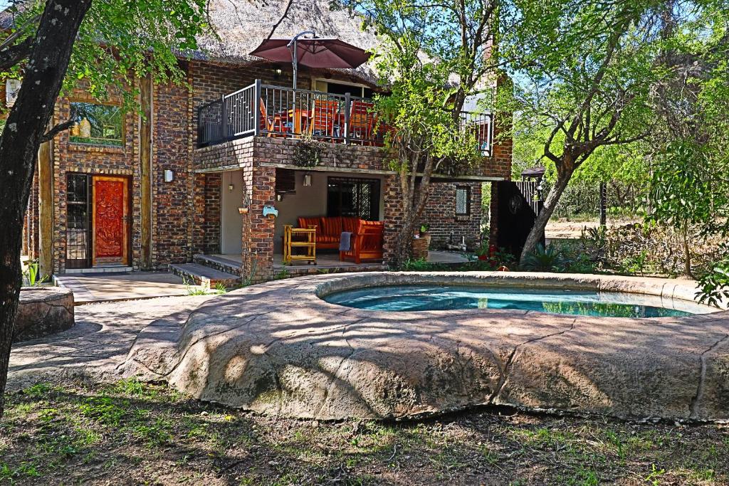 玛洛斯帕克Kruger Park Hostel的庭院中带游泳池的房子