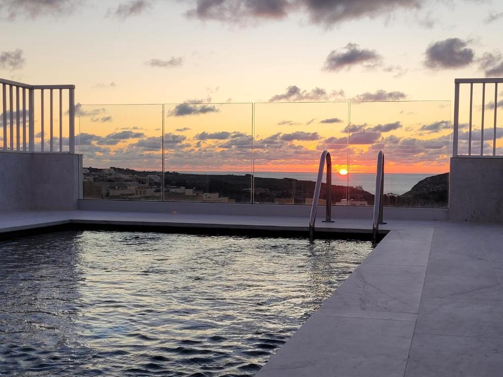 维多利亚Anici Crt Penthouse 4 - with private rooftop pool的享有日落美景的大楼设有游泳池