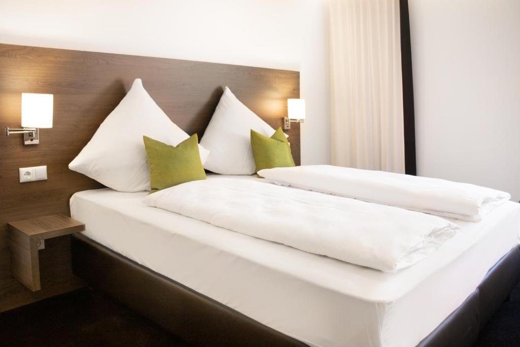 因戈尔施塔特MO Hotel by WMM Hotels的一间卧室配有两张带绿色和白色枕头的床