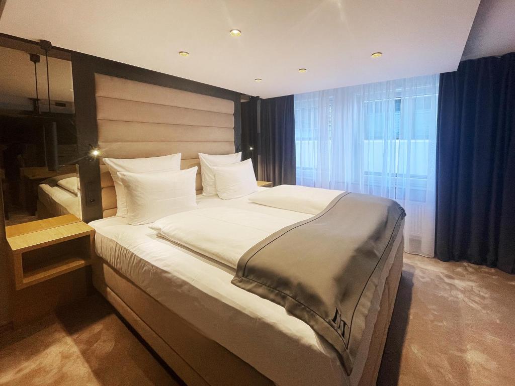 罗伊特林根DORMERO Hotel Reutlingen的卧室配有带白色枕头的大床