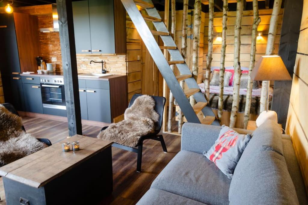 AttreLa cabane du cerf et son sauna的带沙发和楼梯的客厅