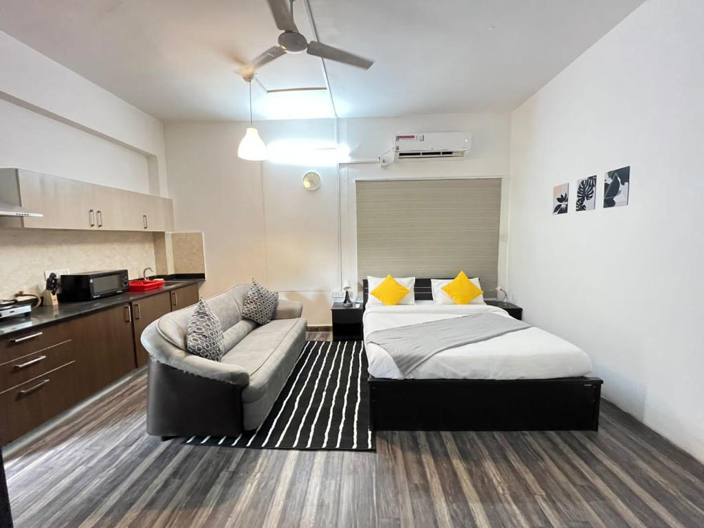 海得拉巴BedChambers Serviced Apartment, Jubilee Hills的一间卧室配有一张床和一张沙发,还设有一间厨房