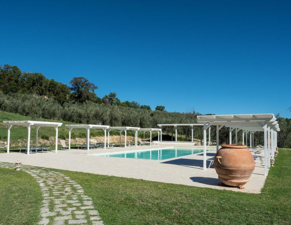 PapignoIl Borgo Di San Michele的庭院内带凉棚和大花瓶的游泳池