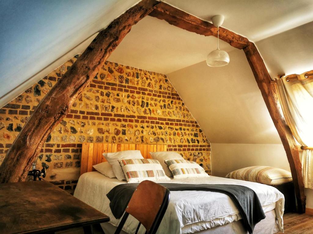 Octeville-sur-MerEcolodge ENTRE MER & CAMPAGNE - Maison d'Hôtes POMME DE PAILLE - Entre Honfleur et Etretat的阁楼上的卧室配有一张大床