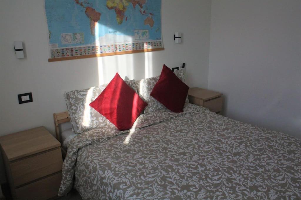 马格拉Cà Maurizio Venezia的一间卧室配有一张带两个红色枕头的床