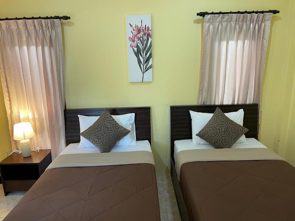 邦涛海滩Bangtao Hello House的两张睡床彼此相邻,位于一个房间里