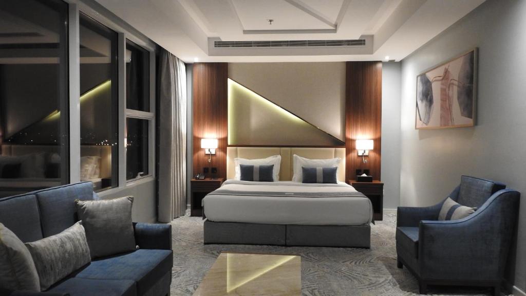 吉达فندق ليفيل ناين Level Nine Hotel的一间卧室配有一张床、两把椅子和一张沙发