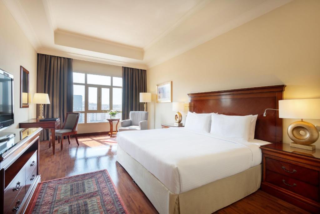 多哈多哈协和大酒店的酒店客房,配有床和电视