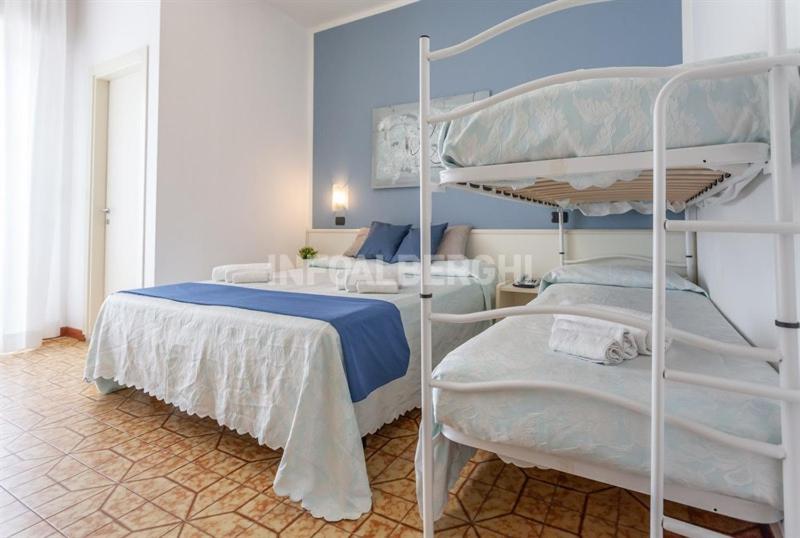 圣毛罗马尔HOTEL CONTI的一间卧室设有两张双层床,拥有蓝色的墙壁。