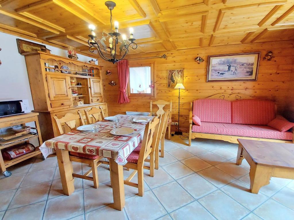 萨莫安斯Appartement Samoëns, 3 pièces, 4 personnes - FR-1-624-54的一间带桌子和红色沙发的用餐室