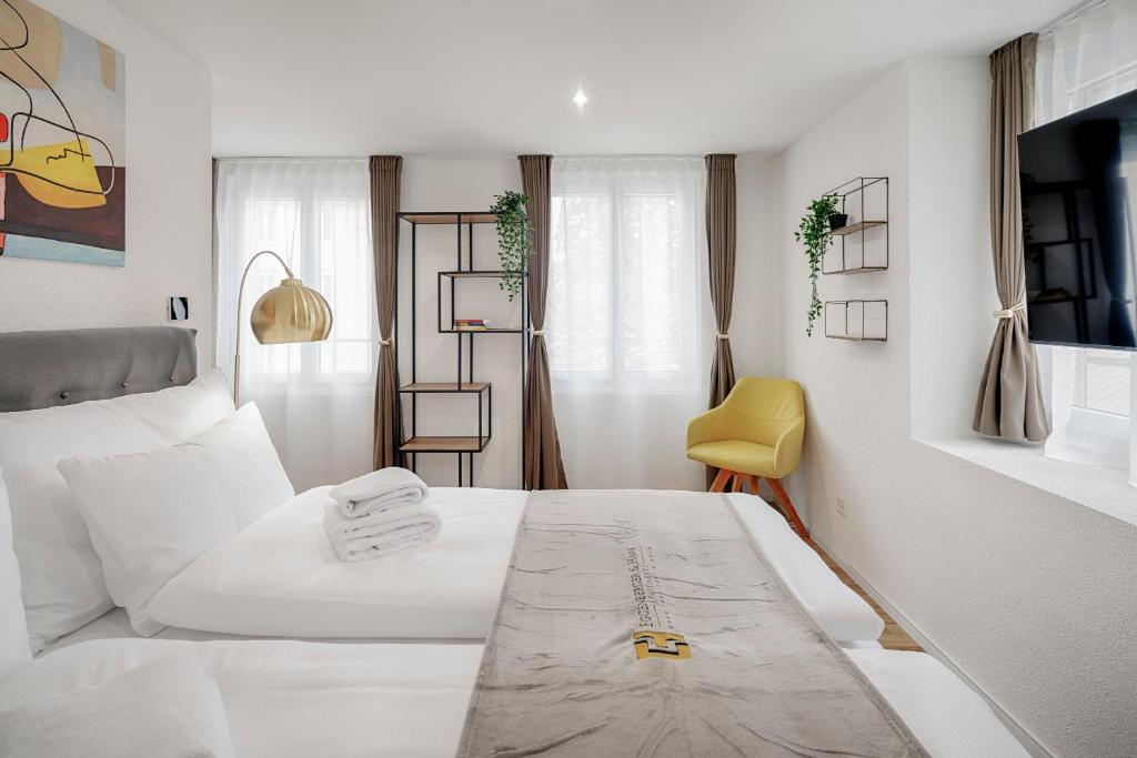 圣加仑EH Apartments Jupiter的卧室配有白色的床和黄色椅子
