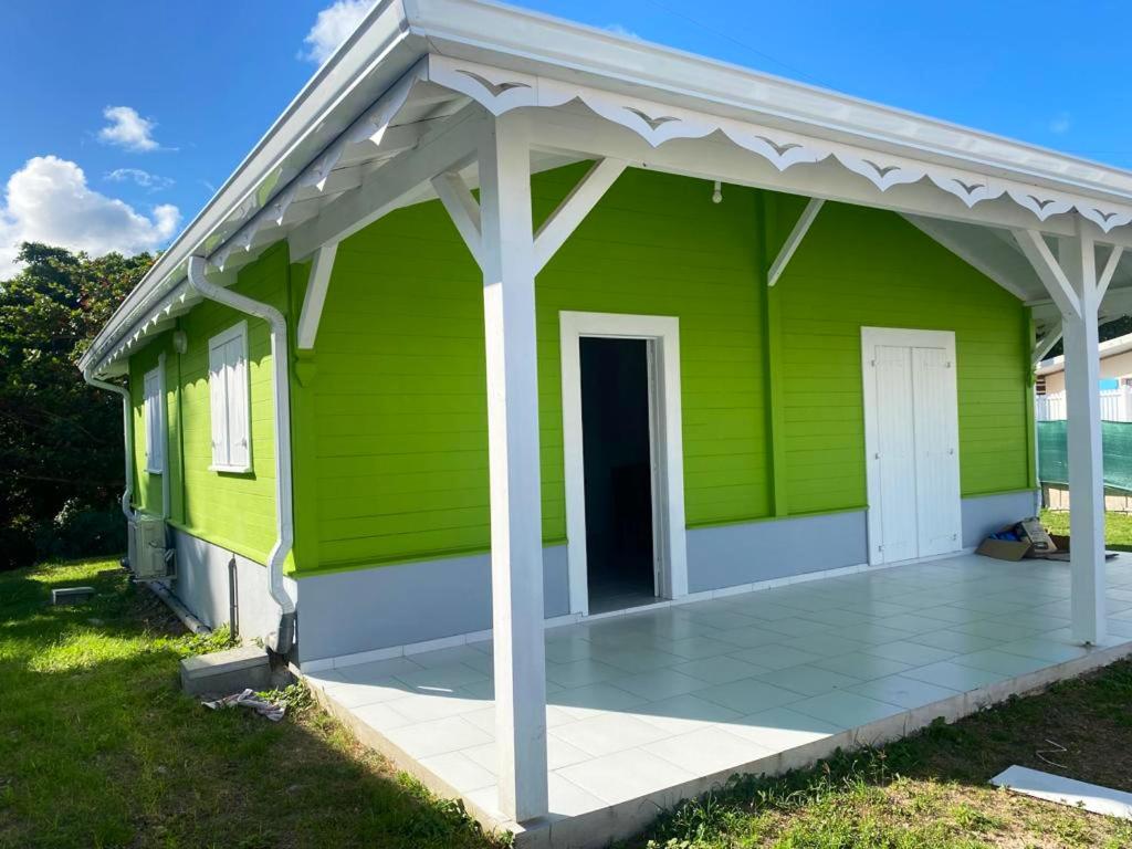 勒沃克兰Maison de 2 chambres a Le Vauclin a 500 m de la plage avec jardin clos的白色屋顶的绿色房子