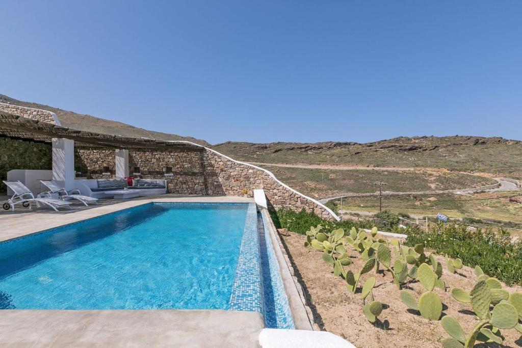 帕诺尔莫斯米科诺斯Elegant Mykonos Villa Air Private Pool 4 Bedrooms Sea View Panormos的房屋前的游泳池