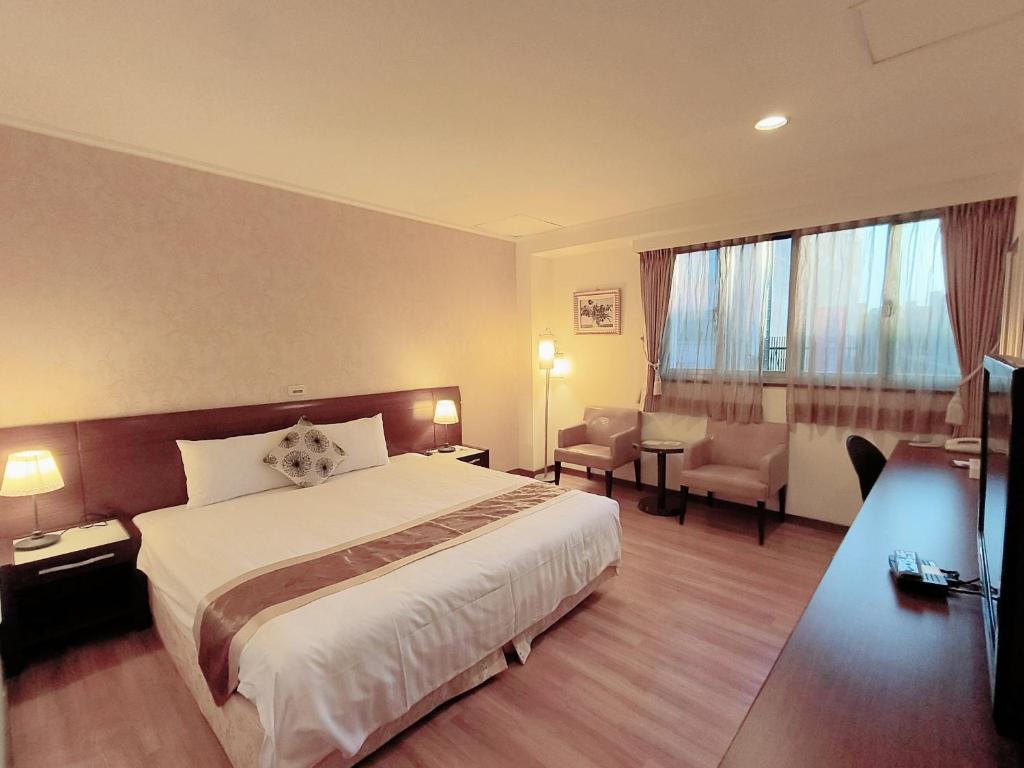 台南文化信然的酒店客房设有一张床和一个大窗户