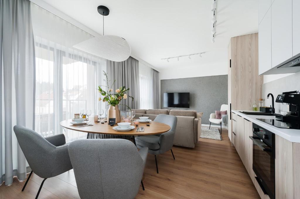 米科瓦伊基Lake Club Apartments by LoftAffair的厨房以及带桌椅的起居室。