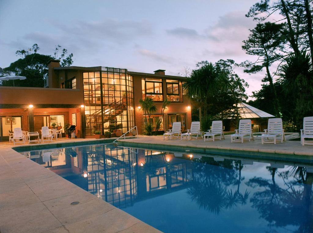 埃斯特角城埃斯特角林孔度假酒店的房屋前有游泳池的房子