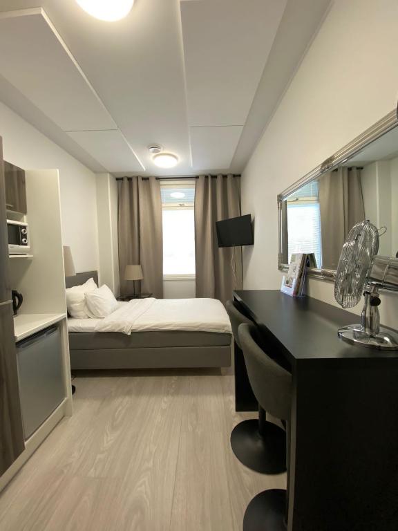 PyhäntäAkselin & Elinan Asema Oy的酒店客房带一张床铺、一张书桌和一间卧室