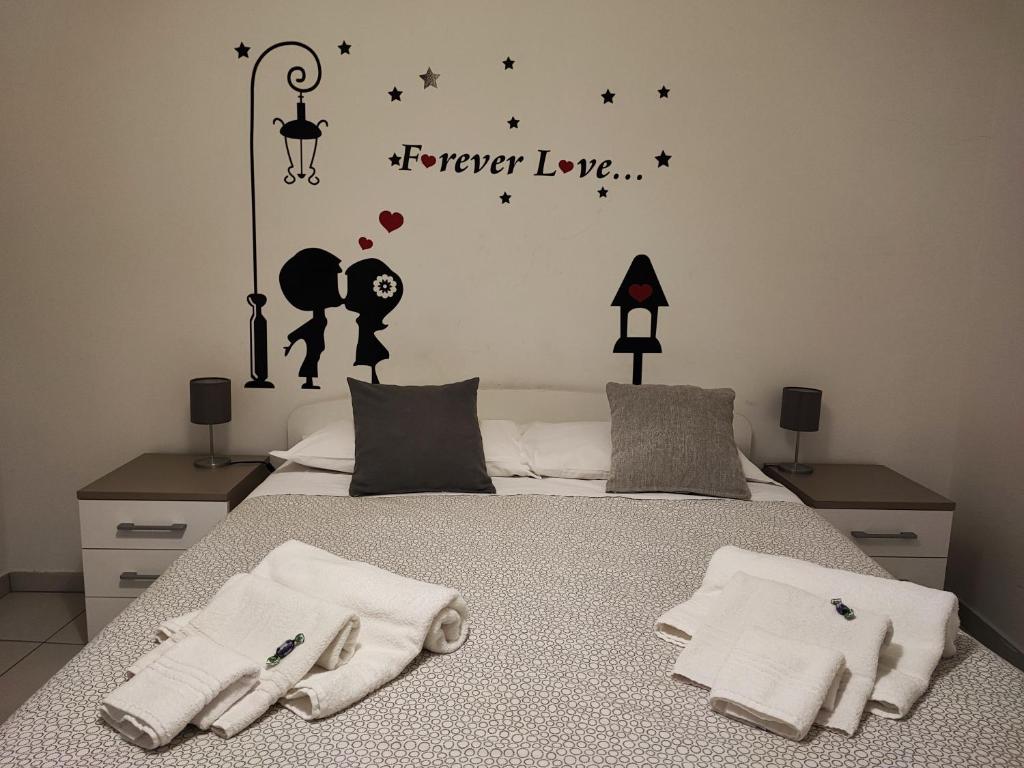 卡塔尼亚mungiBEDdu Apartment的卧室配有一张床,其中有永远爱的词