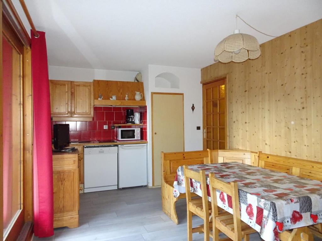 普拉洛尼昂拉瓦努瓦斯Appartement Pralognan-la-Vanoise, 3 pièces, 6 personnes - FR-1-464-78的一间带桌子的厨房和一间带红色瓷砖的厨房