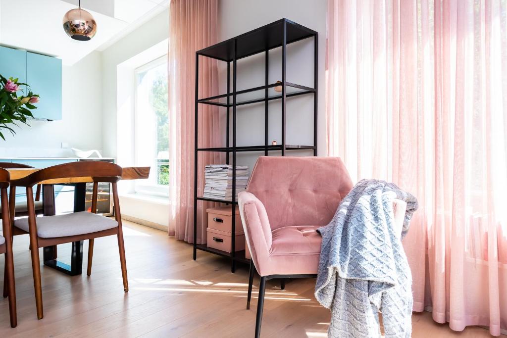 塔林Fabulous Location Apartments Deluxe的客厅配有粉红色的椅子和书桌