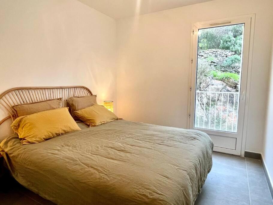 圣拉斐尔Vue panoramique - résidence calme - St Raphaël的卧室里一张带黄色枕头的床,卧室里设有窗户