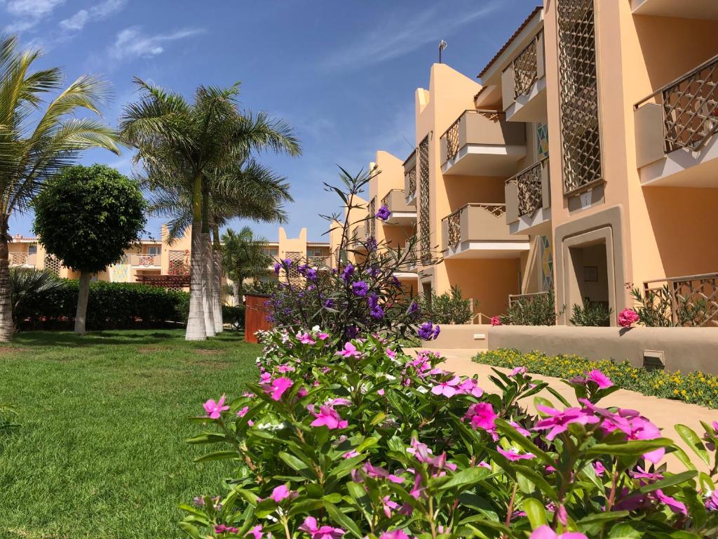 圣玛丽亚Tropical Morabeza Apartment Santa Maria的粉红色花卉建筑外景
