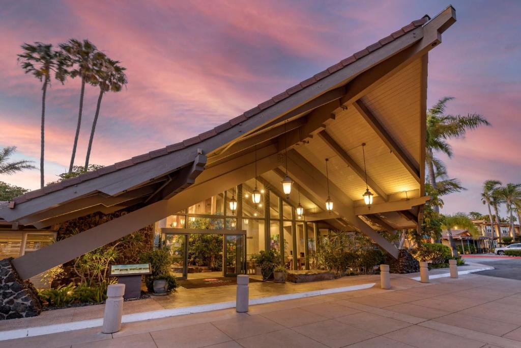 圣地亚哥棕榈岛海滨贝斯特韦斯特PLUS酒店的一座有遮阳篷和棕榈树的建筑
