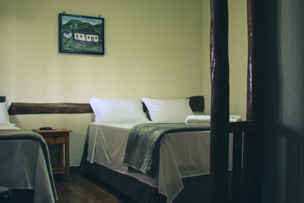 瓦尔任博尼塔Pousada Chalés do Rancho Canastra的一间卧室配有带白色枕头的床