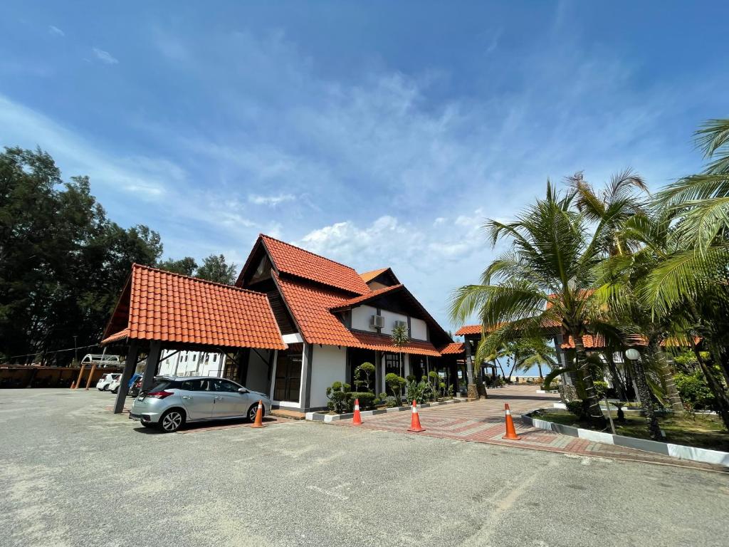 瓜拉丁加奴DSH Batu Burok Beach Resort的停在房子前面的停车场的汽车