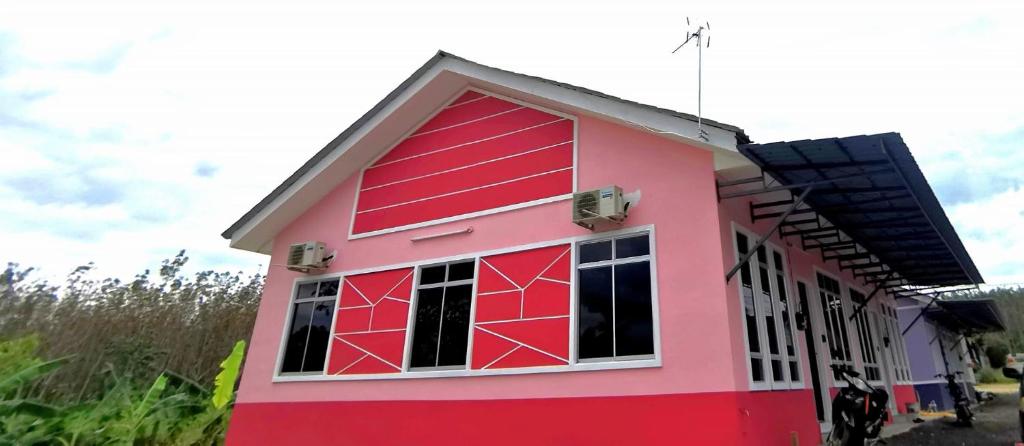 PendangAz HOMESTAY PENDANG KEDAH的红色屋顶的粉红色房子