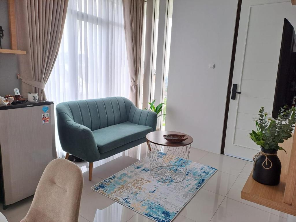 万隆Tabebuya Rumah Liburan Keluarga的客厅配有绿色椅子和桌子