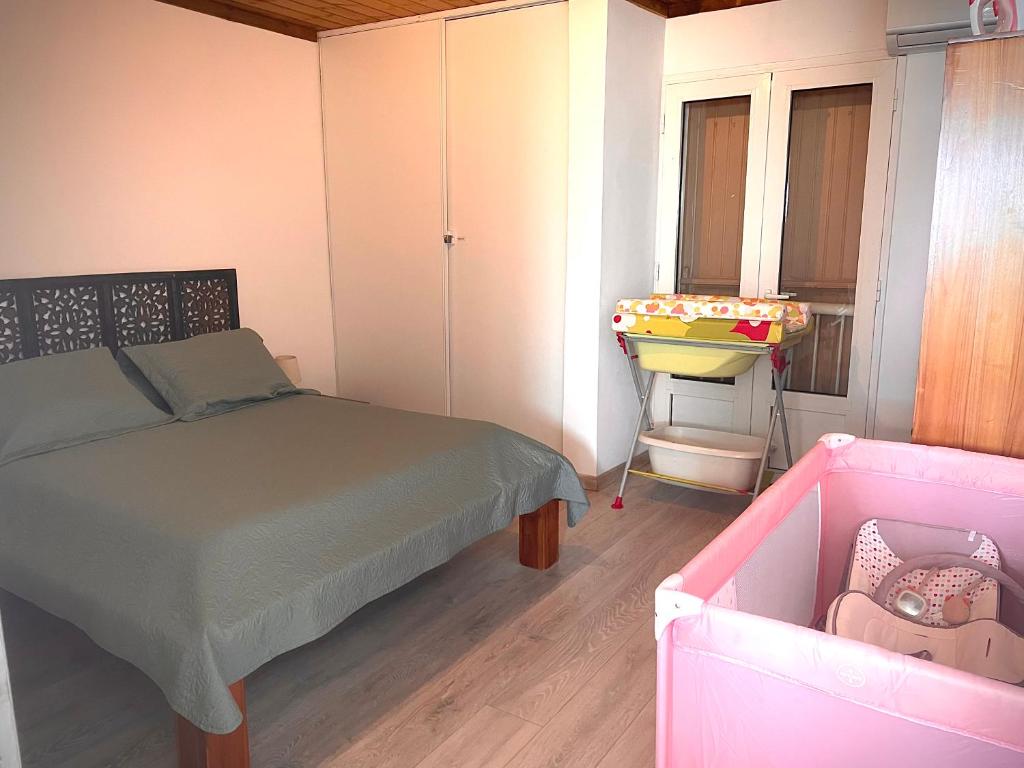 珀蒂蒂勒Alambic de Grand Anse的一间卧室配有一张床、一张婴儿床和一个水槽